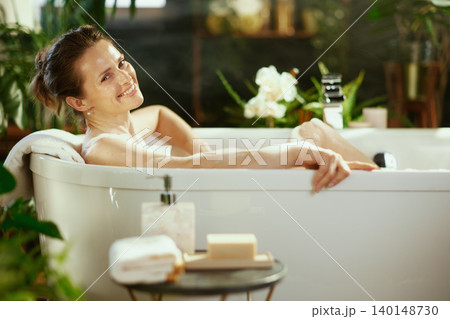 Smiling Woman Enjoying a Tranquil Bubble Bath Smiling Woman Enjoying a Tranquil Bubble Bath 140148730