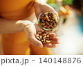 Woman Holding a Jar of Gourmet Mixed Nuts 140148876