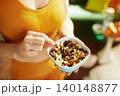 Woman in Orange Activewear with Nut and Fruit Mix 140148877