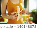 Fit Woman Peeling a Fresh Banana for a Snack 140148878
