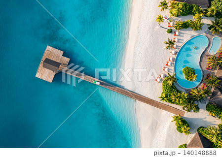 Stunning aerial Maldives wooden pier infinity pool white sand turquoise lagoon breathtaking luxury resort top view tropical paradise serene idyllic coastal escape drone dreamy vibrant exotic scenic Stunning aerial Maldives wooden pier infinity pool white sand turquoise lagoon breathtaking luxury resort top view tropical paradise serene idyllic coastal escape drone dreamy vibrant exotic scenic 140148888