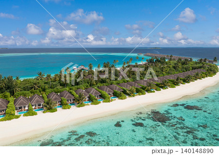 Amazing aerial Maldives island overwater villas powdery white sand turquoise lagoon breathtaking luxury resort tropical paradise serene idyllic coastal escape drone dreamy vibrant exotic wide vista 140148890