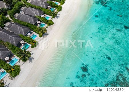 Amazing aerial Maldives villas private pools powdery white sand turquoise lagoon breathtaking luxury resort top view tropical paradise serene idyllic coastal escape drone dreamy vibrant exotic getaway Amazing aerial Maldives villas private pools powdery white sand turquoise lagoon breathtaking luxury resort top view tropical paradise serene idyllic coastal escape drone dreamy vibrant exotic getaway 140148894