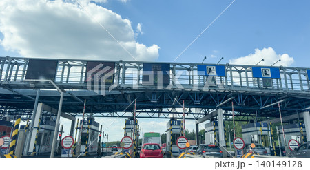 Toll plaza checkpoint with payment lanes cars and highway infrastructure under blue sky in Poland Toll plaza checkpoint with payment lanes cars and highway infrastructure under blue sky in Poland 140149128