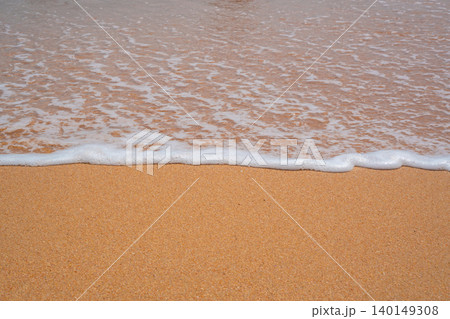 Gentle sea foam reaches a sandy beach in Sharm El Sheikh Egypt with shallow water along the Red Sea shoreline in daylight. Beach resort lifestyle 140149308