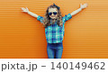 Happy cheerful kid girl with curly hair, joyful little child having fun in the city on orange wall 140149462