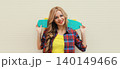 Stylish young blonde woman posing with skateboard on city street 140149466