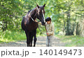 Teenager boy kid with horse walking in summer forest, horseback riding 140149473