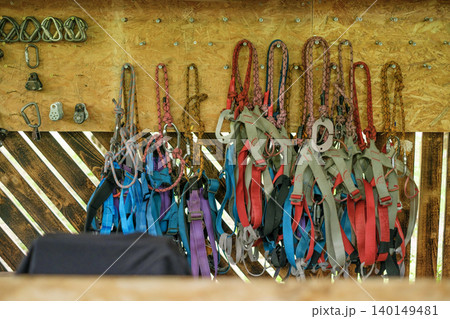 Safety belts and climbing carabiners on the wall in the outdoor park 140149481