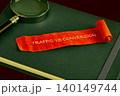 A vibrant orange ribbon displays the phrase traffic vs conversion, resting atop a dark green notebook with a magnifying glass nearby, symbolizing analysis in marketing 140149744