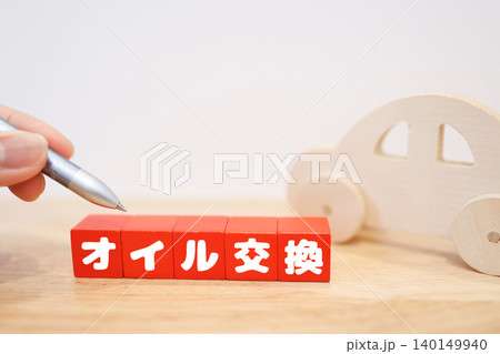 オイル交換。赤ブロック文字と木製おもちゃの車。コピースペース オイル交換。赤ブロック文字と木製おもちゃの車。コピースペース 140149940