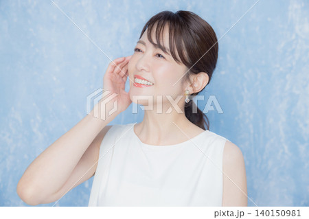 顔に手を当てて微笑む女性 顔に手を当てて微笑む女性 140150981