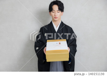 着物姿でご祝儀を持つ若い男性 140151130