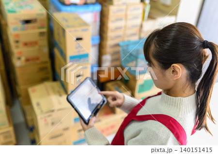 倉庫でタブレット操作する女性 140151415