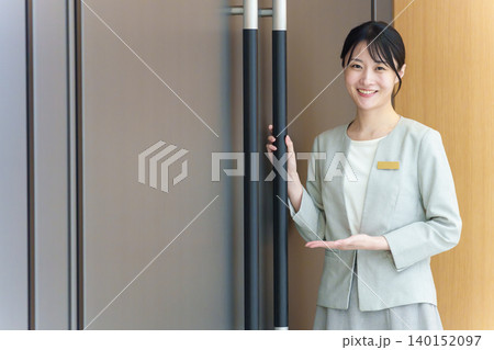ドアの前に立つ受付の女性 140152097