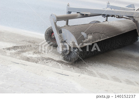 Tractor cleaning asphalt with brushes close-up Tractor cleaning asphalt with brushes close-up 140152237