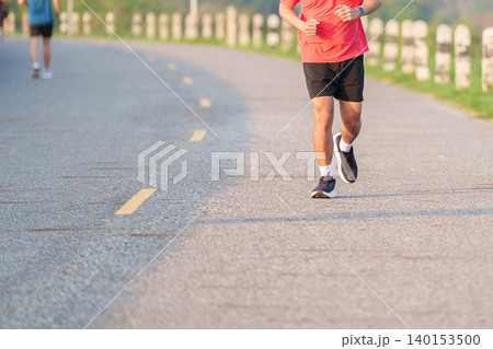 Active young Asian man jogging and running in the public park at morning. Male athlete in sportswear exercising for healthy lifestyle and fitness workout outdoors. Wellness and sport concepts Active young Asian man jogging and running in the public park at morning. Male athlete in sportswear exercising for healthy lifestyle and fitness workout outdoors. Wellness and sport concepts 140153500