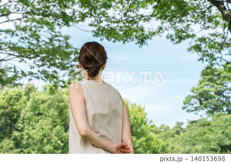 青空の見える公園,森を歩く,散歩をする女性の後ろ姿(森林浴,オーガニック,エコ) 青空の見える公園,森を歩く,散歩をする女性の後ろ姿(森林浴,オーガニック,エコ) 140153698