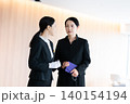 葬儀場でスタッフと話す女性 140154194