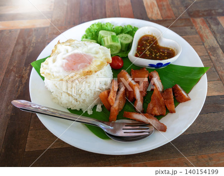fried pork belly with rice and fried egg 140154199