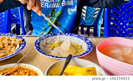 A close-up of papeda, a traditional Papuan and Maluku dish. It has a thick texture and a bland taste, but is delicious when paired with yellow fish soup or other side dishes. A close-up of papeda, a traditional Papuan and Maluku dish. It has a thick texture and a bland taste, but is delicious when paired with yellow fish soup or other side dishes. 140154853