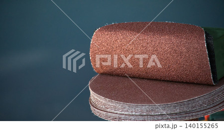 Stack of round sandpaper discs for orbital sander, close-up detail Stack of round sandpaper discs for orbital sander, close-up detail 140155265