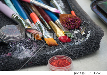 Assortment of art brushes and glitter pots ready for creative application 140155266