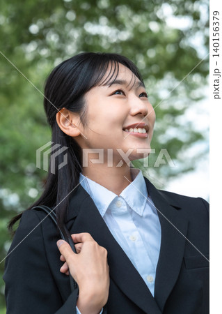 新緑を背に笑顔で見上げるリクルートスーツ姿の若い女性 新社会人 就活 新緑を背に笑顔で見上げるリクルートスーツ姿の若い女性 新社会人 就活 140156379