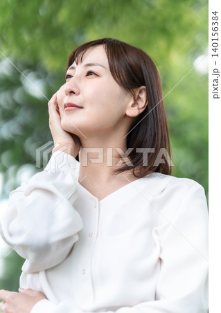 屋外で肌をケアする笑顔の女性 アンチエイジング 新緑 広告素材 屋外で肌をケアする笑顔の女性 アンチエイジング 新緑 広告素材 140156384