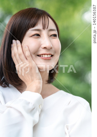 屋外で肌をケアする笑顔の女性 アンチエイジング 新緑 広告素材 屋外で肌をケアする笑顔の女性 アンチエイジング 新緑 広告素材 140156387
