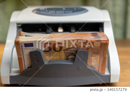 Cash counting machine with 50 Euro banknotes stack close up 140157279