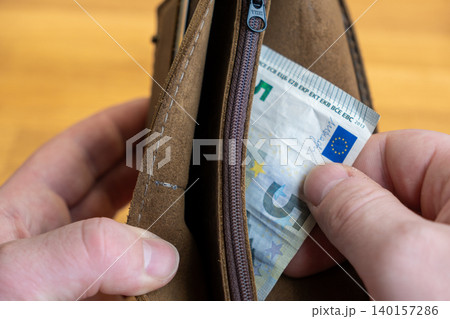 Man taking out last 5 Euro banknote from empty wallet, poverty concept 140157286