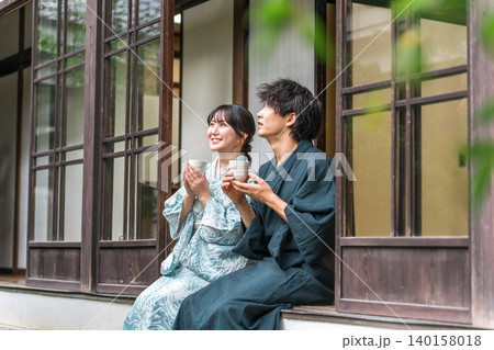 旅行で温泉旅館・宿坊・古民家の縁側でお茶を飲む夫婦・カップル 140158018
