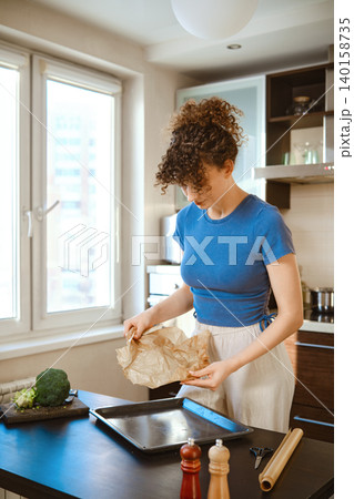 Preparation of smashed broccoli with cheese in a kitchen setting during daytime Preparation of smashed broccoli with cheese in a kitchen setting during daytime 140158735