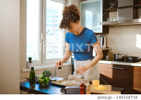 Preparation of smashed broccoli with cheese in a modern kitchen during daylight Preparation of smashed broccoli with cheese in a modern kitchen during daylight 140158738