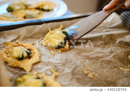 Smashed broccoli being prepared with cheese on a baking tray in a home kitchen Smashed broccoli being prepared with cheese on a baking tray in a home kitchen 140158743