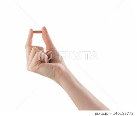 Female hand hold beige pill isolated on white Female hand hold beige pill isolated on white 140158772