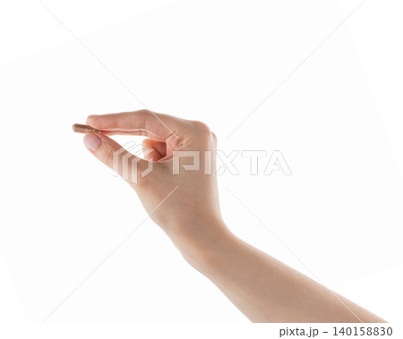Female hand hold beige pill isolated on white Female hand hold beige pill isolated on white 140158830