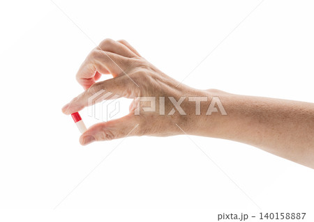 Mid aged female hold red and white pills isolated on white Mid aged female hold red and white pills isolated on white 140158887