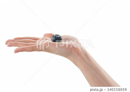 Female hand hold big blueberry isolated on white Female hand hold big blueberry isolated on white 140158939