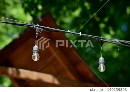 Outdoor string light bulbs by wooden roof 140159298