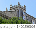 Historic ornate rooftop above green trees 140159306