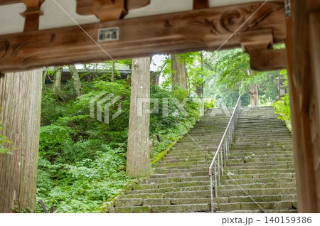 大山寺山門の木造建築越しに望む苔むした長い石段と新緑の境内風景（鳥取県大山町） 140159386