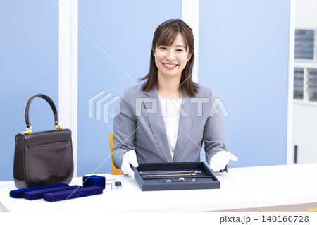 買取業者　窓口で査定をしている女性 140160728