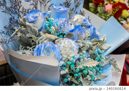A beautiful birthday bouquet with tinted blue roses, carnation and silver leaves for sale at the famous Flower Market in Hong Kong. A beautiful birthday bouquet with tinted blue roses, carnation and silver leaves for sale at the famous Flower Market in Hong Kong. 140160814