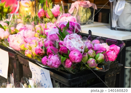 Fresh pink peony bouquets on a flower shop shelf in Hong Kong with a handwritten price tag indicating large peonies Fresh pink peony bouquets on a flower shop shelf in Hong Kong with a handwritten price tag indicating large peonies 140160820