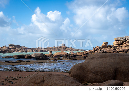Granite shoreline opening toward distant island in Tregastel, Brittany, France 140160903