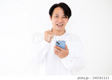 スマホを見てガッツポーズするカジュアルのミドル男性 スマホを見てガッツポーズするカジュアルのミドル男性 140161121