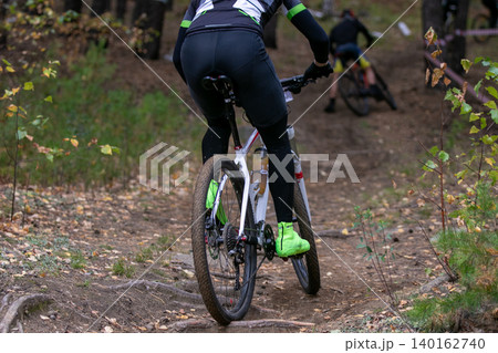 Rear view mountain biker riding 140162740