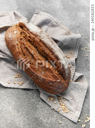 Rustic rye sourdough bread loaf on gray cloth Rustic rye sourdough bread loaf on gray cloth 140162853